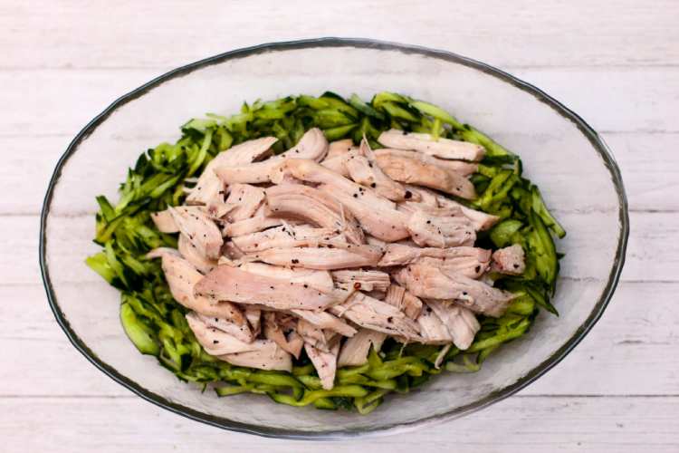 きゅうり、鶏肉、ねぎ、生姜を盛り付け、胡麻ダレをかける